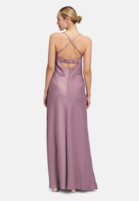 Długa, bezrękawna lawendowa sukienka z gładkiego satyny. Posiada dekolt w kształcie łezki z falbanami oraz skrzyżowane ramiączka dla dodatkowego efektu.