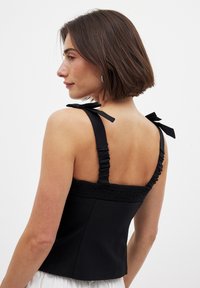Musthave mustahututeks mustahuul kuudeli gahtid, kuski pehme ʻō päevadárstraped muidu ühtaset needest veste. Sujuv kangas koos sobitumas disainiga.