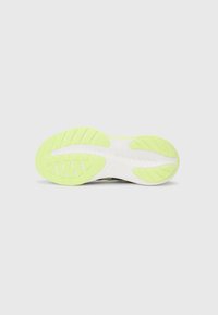 Sole of a running shoe with light green tread patterns and white midsole, designed for traction and flexibility.