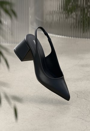 Black leather slingback heel with a pointed toe, featuring a wide, geometric block heel and a minimalist design. Smooth texture with sleek lines.