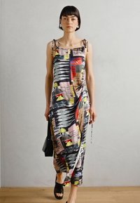 Abito maxi con spalline sottili, stampa astratta colorata in tonalità di nero, giallo, rosso e rosa; tessuto leggero e fluido, dettaglio con spacco laterale.