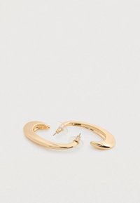 Σκουλαρίκια από μέταλλο με χρυσή απόχρωση, με καμπυλωτό, ανοιχτό σχέδιο. Διαφανές πίσω μέρος και λεπτομέρειες κλεισίματος με καρφίτσα ορατές. Λείο, γυαλιστερό επιφάνεια.