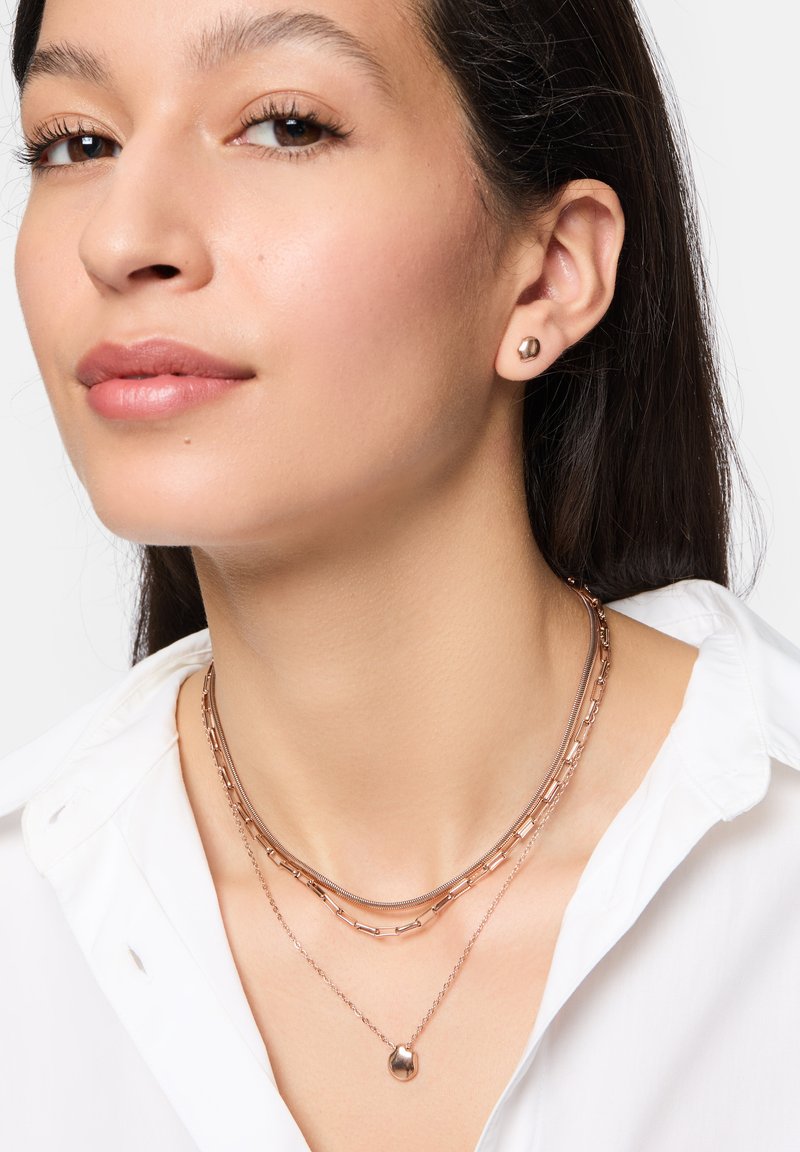 Schmuckset aus Roségold mit geschichteten Halsketten in unterschiedlichen Kettendesigns und Ohrsteckern. Glatte, polierte Oberfläche und moderne Formen.
