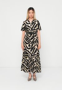 Short-sleeve, button-down dress with a black and beige animal print, cinched at the waist with a black belt, flowing to ankle length.