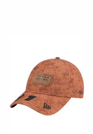 Casquette marron avec un motif texturé, des écussons de marque noirs et une fermeture ajustable. La visière incurvée et les accents brodés améliorent le design.