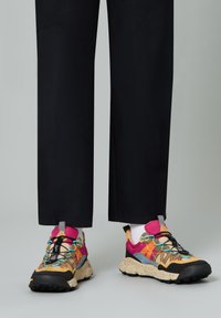 Colorful multi-patterned sneakers with a mix of brown, pink, and blue accents, featuring a speckled beige sole and black laces.