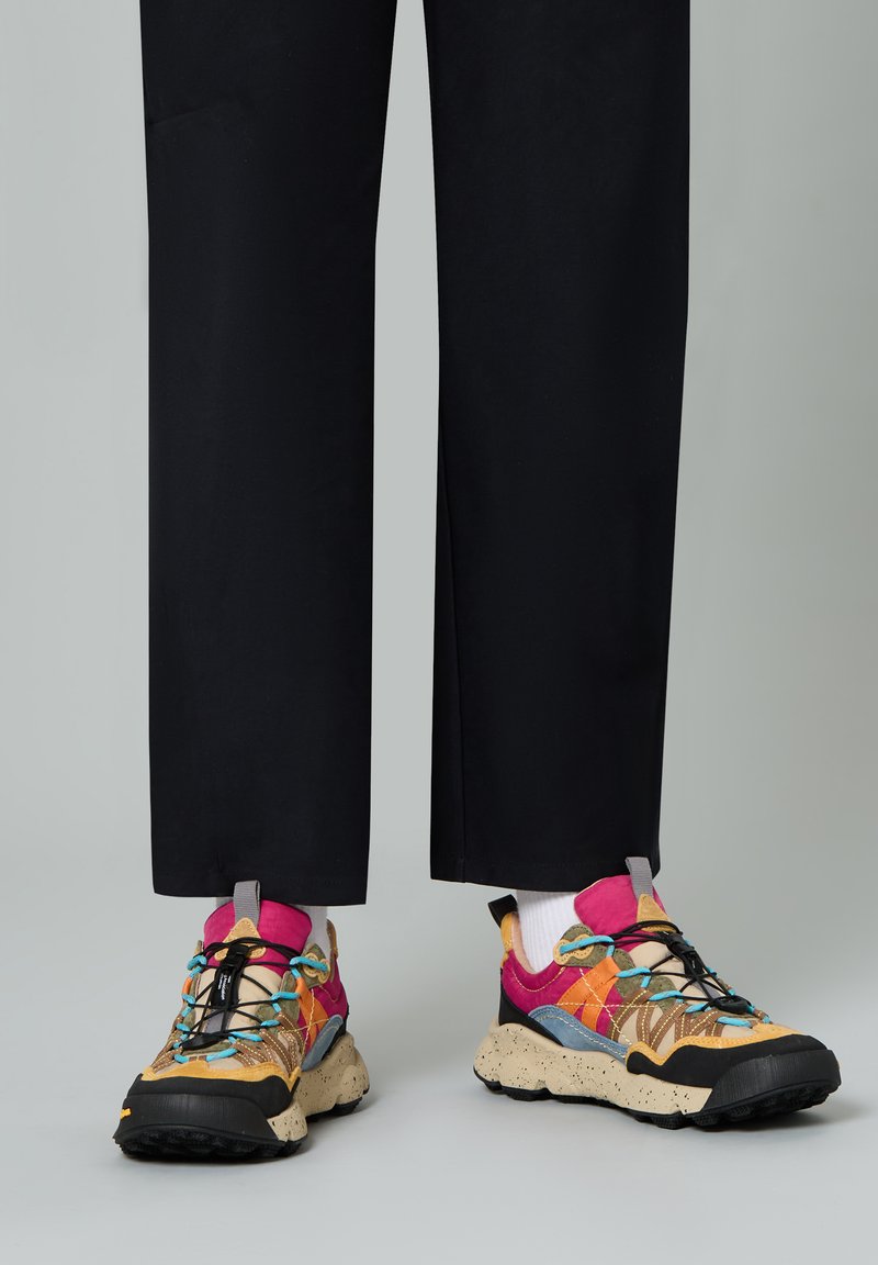 Colorful multi-patterned sneakers with a mix of brown, pink, and blue accents, featuring a speckled beige sole and black laces.