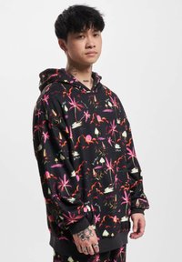 Hooded sweatshirt in black fabric featuring a vibrant tropical print with palm trees, mountains, and clouds in pink, yellow, and white.