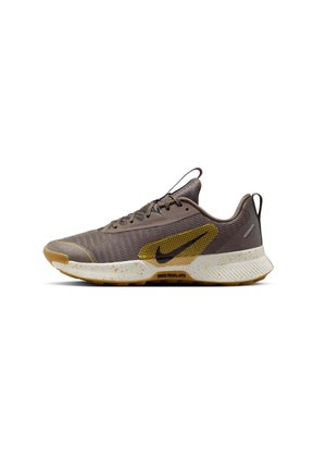 Brown athletic shoe with mesh upper, yellow accents, textured sole, and visible speckles. Lace-up design with a pull tab on the heel.