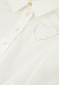Witte overhemd met knopen, met een gestikte hartdetail aan de linkerkant, een kraag en parelachtige knopen met een gouden hartaccent.