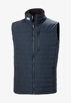 Námorní vestový kabát s vysokým límcem, předním zipem a dvěma bočními kapsami se zipem. Má červené akcenty na límci.