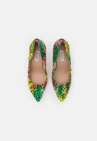 Ballerines pointues colorées présentant un motif léopard en vert, rose, jaune et noir, avec un matériau lisse et une semelle intérieure rembourrée.