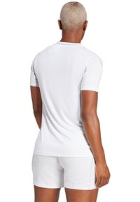 Witte sportshirt met korte mouwen, een ronde hals en een gladde textuur, gecombineerd met witte shorts, gezien vanuit de achterkant.