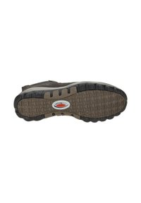 Bruine sneakeronderkant met een gestructureerde rubberen zool, voorzien van een geometrisch patroon en een ingebed logo in een ronde tag.