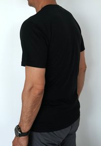 Schwarzes Baumwoll-T-Shirt mit kurzen Ärmeln und rundem Halsausschnitt, von hinten gezeigt, mit einer glatten Textur und normaler Passform.