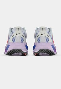 Scarpe da corsa Nike con una tomaia in rete grigia chiara, dettagli viola e una suola nera testurizzata con dettagli rosa. Ammortizzazione Zoom Air visibile.