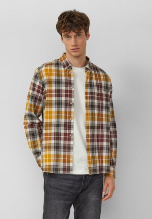 Karierte Flanellhemd mit gelben, braunen und weißen Mustern und Knopfverschluss. Wird über einem weißen T-Shirt getragen, mit langen Ärmeln und einem lockeren Schnitt.