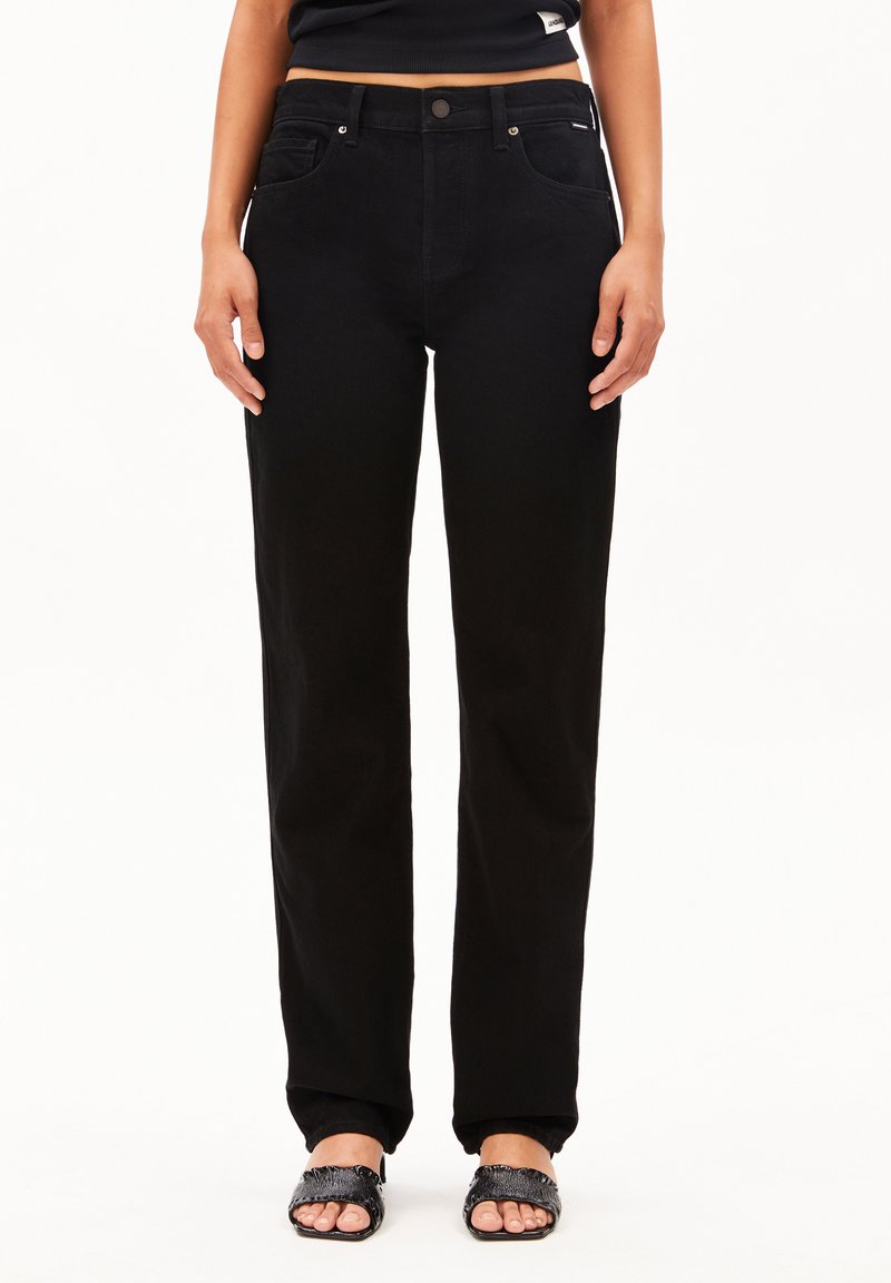 Pantalon en denim noir à jambes droites avec un design à cinq poches, dotés d'une fermeture à bouton et d'un branding discret sur la ceinture. Texture lisse.