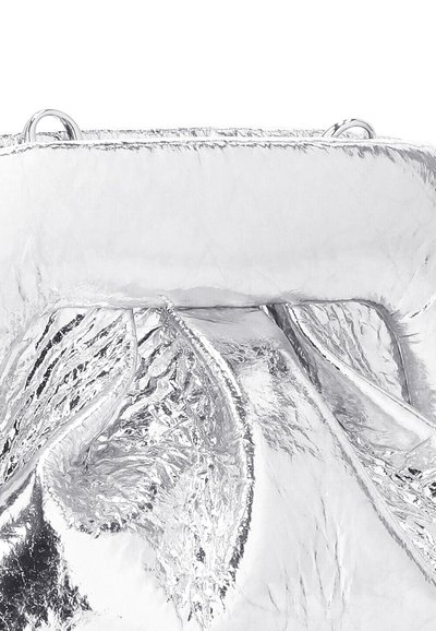 Borsa a mano metallica argento con una consistenza increspata, dotata di una chiusura a ribaltina e dettagli in metallo circolare. Superficie lucida con qualità riflettente.