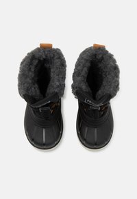 Une paire de bottes d'hiver noires avec une doublure en polaire grise, des semelles en caoutchouc et des sangles ajustables, vues de dessus sur un fond blanc.