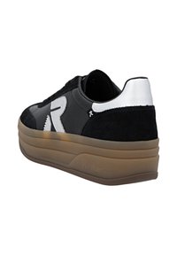 Baskets noir et blanc avec une épaisse semelle marron, grand "R" brodé sur le côté, et des détails en daim au niveau du talon et des orteils.