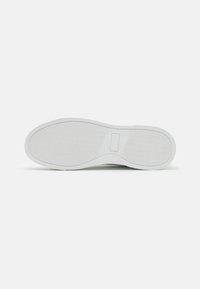 White footwear sole with a textured rubber surface, featuring a rectangular design in the center and a smooth edge.
