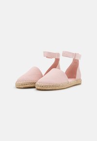 Roze canvas espadrilles met een ronde neus, jute zool en verstelbare enkelriem. Glad textuur, lichtgewicht ontwerp ideaal voor warm weer.