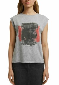 Grijze katoenen pullover met kapmouwen, voorzien van een zwart en rood abstract grafisch patroon. De tekst onderaan luidt "GEWEVEN WARP EN WEFT."