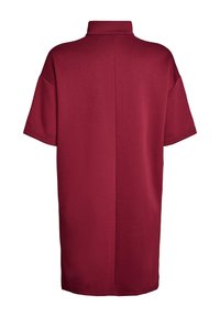 Bordeaux oversized poloshirt met korte mouwen, voorzien van een hoge kraag en een gladde textuur, ontworpen in een losse, rechte snit.