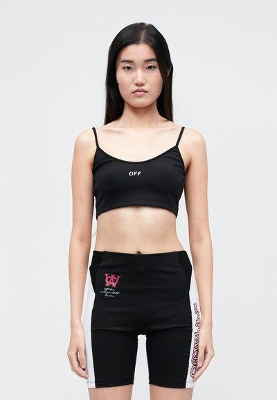 Černý crop top s bílým nápisem "OFF", kombinovaný s černobílými vysokými cyklistickými šortkami s grafickými potisky a kontrastními panely.