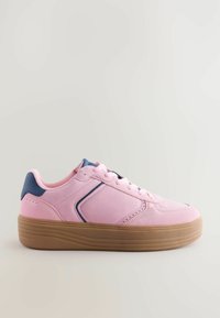 Baskets en daim rose clair avec des accents bleu marine, bout rond et semelle en caoutchouc texturé de couleur gomme. Elles possèdent des lacets plats et des détails de couture visibles.