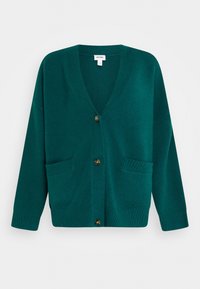 Tyrkysový cardigan s výstřihem do V, zapínáním na knoflíky a dvěma předními kapsami. Vyroben z měkkého materiálu s žebrovanými detaily na manžetách a lemu.