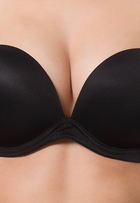 Zwarte push-up beha met een gladde stof, gevormde cups en een naadloos ontwerp. Voorzien van een kantafwerking langs de band en een subtiele glans.