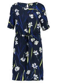 Kansimökeisin kukkamekko tummansinisellä taustalla, jossa on lyhyet hihat, valkoisia kukkia ja vihreitä yksityiskohtia, vyötäröllä vyö ja avoneck-pistokkeella.