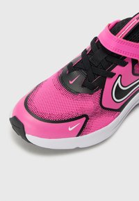 Chaussure de sport avec un dessus en maille rose, des accents noirs et un logo swoosh blanc. Dispose d'un col rembourré et d'un système de laçage pour un maintien sécurisé.