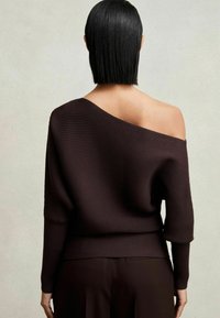 Braun gestreiftes Off-Shoulder-Sweatshirt mit langen Ärmeln, taillierter Passform und strukturiertem Stoffdetail. Der Rücken hat einen schlichten Halsausschnitt.