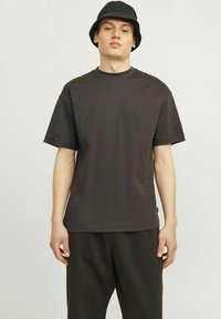 T-shirt in cotone grigio scuro con vestibilità rilassata, maniche corte e collo a giro, abbinato a pantaloni scuri coordinati. Design semplice, senza motivi.