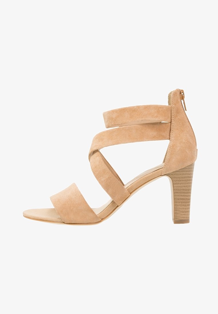 Sandale beige en daim à talon haut bloc, bout ouvert, trois larges brides croisées et fermeture éclair au dos.