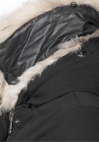 Veste d'hiver noire avec garniture en fausse fourrure beige clair autour de la capuche, une fermeture éclair argentée partiellement visible et des boutons-pression.