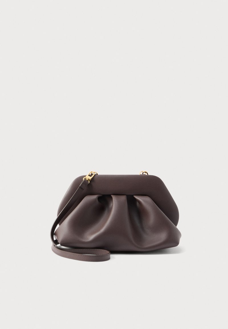 Σκούρο καφέ μαλακό δερμάτινο clutch με χρυσά μεταλλικά στοιχεία και αποσπώμενο λουράκι, με σχεδιασμό σε σούρες σε μονόχρωμο φόντο.