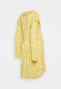 Vestido amarelo com bolinhas pretas e pequenos padrões florais brancos. Apresenta ombros frisados, mangas longas e uma cintura franzida.