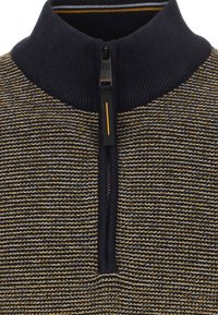 Stickad tröja med halv dragkedja i marinblått och guld, med ett texturerat randmönster, ribbad krage och dragkedjestängning med guldaccent.