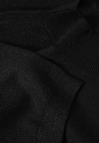 Schwarzer Pullover aus weichem, strukturiertem Stoff, mit gerippten Bündchen und leichtem Schimmer. Keine sichtbaren Muster oder Hardware-Details.