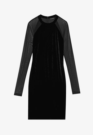 Svart kjole med en fløyelskropp og lange, gjennomsiktige mesh-ermer. Den har en rund utringning og en tettsittende silhuett. Ingen utsmykninger er synlige.