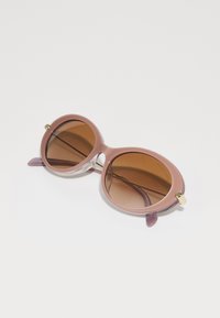 Runde solbriller med gradient rosa ramme, brune linser og lilla akkompagnementsender. Har gullfarget maskinvare ved gangene.