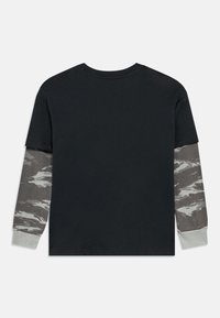 Tricou negru cu mâneci scurte și mâneci lungi cu model camuflaj gri. Accente gri la manșetele mânecilor. Material din bumbac cu textură netedă.