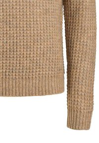 Pull en tricot beige clair avec un motif texturé en relief ; ourlet et poignets côtelés ; présente une coupe décontractée et des manches longues.