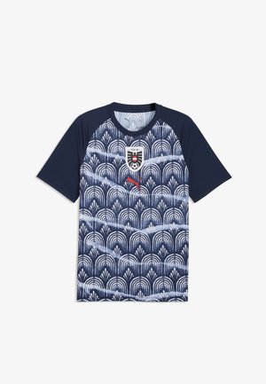 Marineblauw sportshirt met korte mouwen, wit geometrisch patroon, rood Puma-logo en het wapen van het Oostenrijkse voetbalteam op de borst.