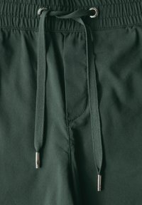 Mörkgröna shorts med elastisk midja, med sn�örning och metalliska detaljer samt en slät tygstruktur.