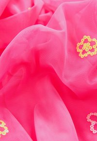 Tissu transparent rose vif avec une apparence légère et texturée, orné d'accents de sequins jaunes formant des motifs circulaires.